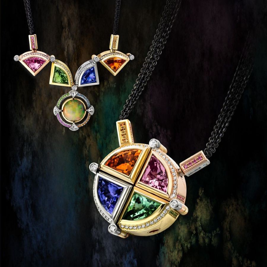 Collier aus verschieden farbigem Gold, mit verschieden farbigen Edelsteinen, die die Elemente, Feuer, Wasser, Erde, Luft symbolisieren sollen. Der Anhänger ist mit 4 farbigen Dreiecken gestaltet, die geschlossen eine runde Form bilden, geöffnet aber eine ganz andere Form zeigen, mit einem vorher verborgenen Mittelstein.