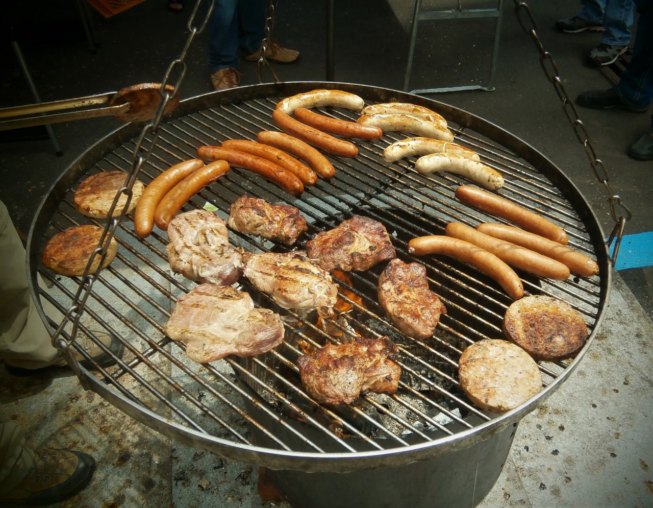Runder Grill mit verschiedenen Bratwürsten und Steaks am Museumsfest